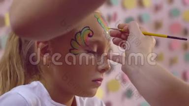 女人用画笔在女孩身上画水纹，脸上画身体